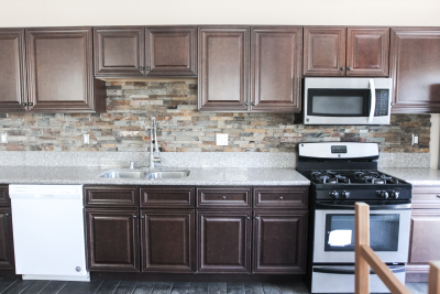 kitchen, dark wood cabinets, silver stove. silver microwave 