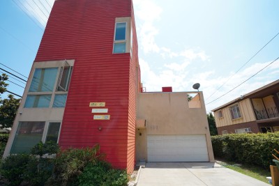 Exterior of tall red and small cream apartment building 
