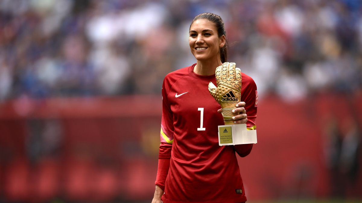 Hope Solo holding Golden Glove trophy.