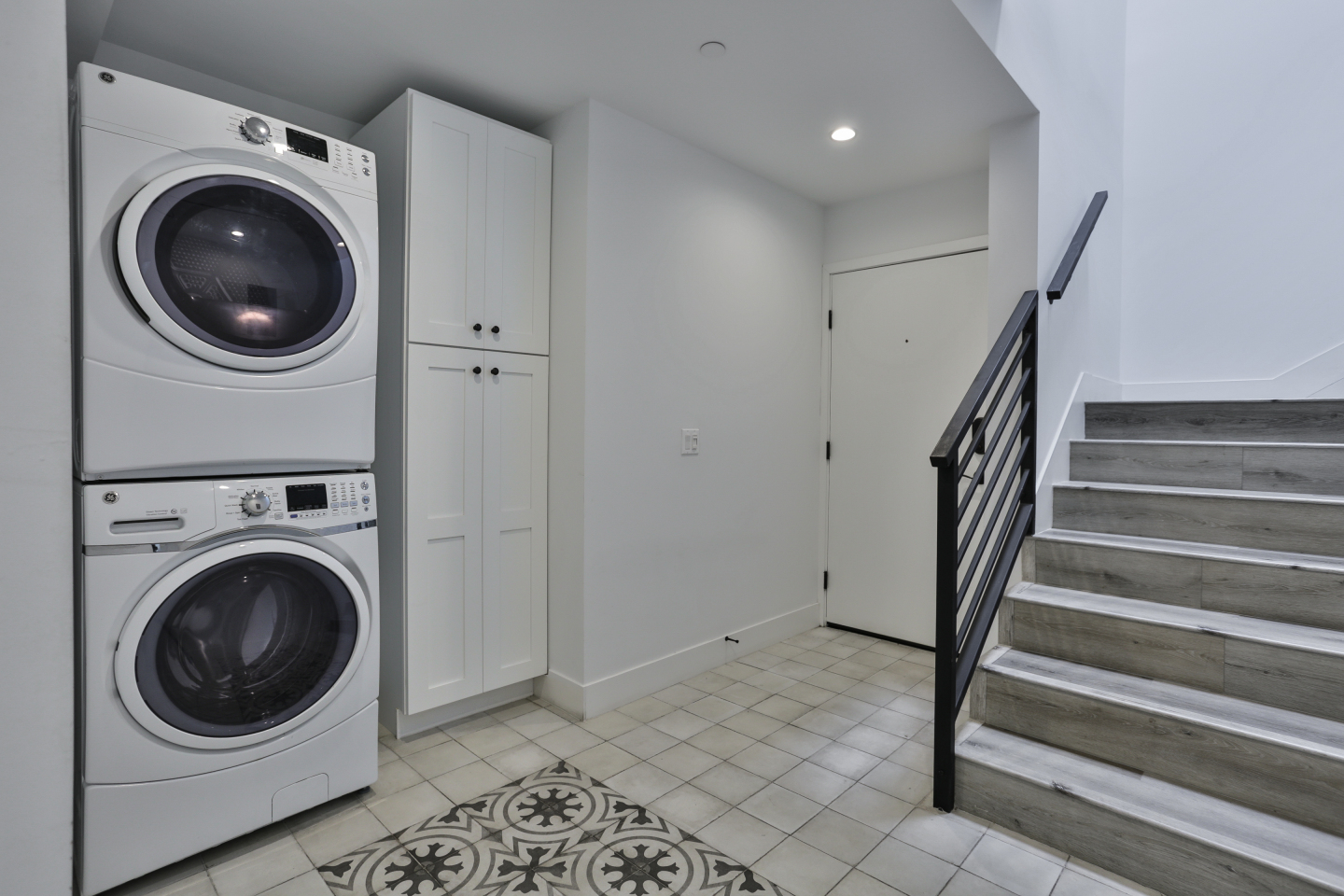 Stacked Washer and Dryer near stairs 