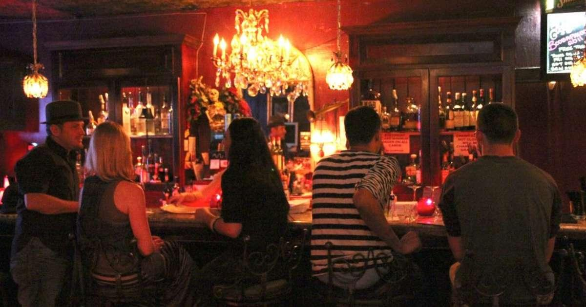 Patrons standing or sitting on bar stools at the R Bar.