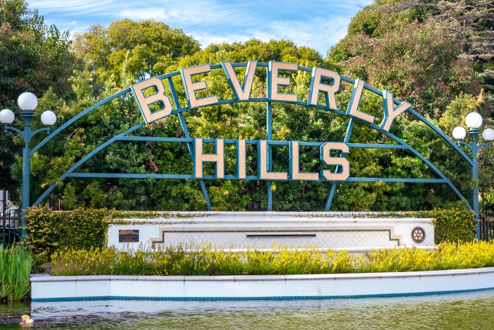 a sign that says beverly hills in front of a body of water