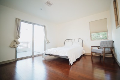 bedroom with white bed, brown hardwood floors 