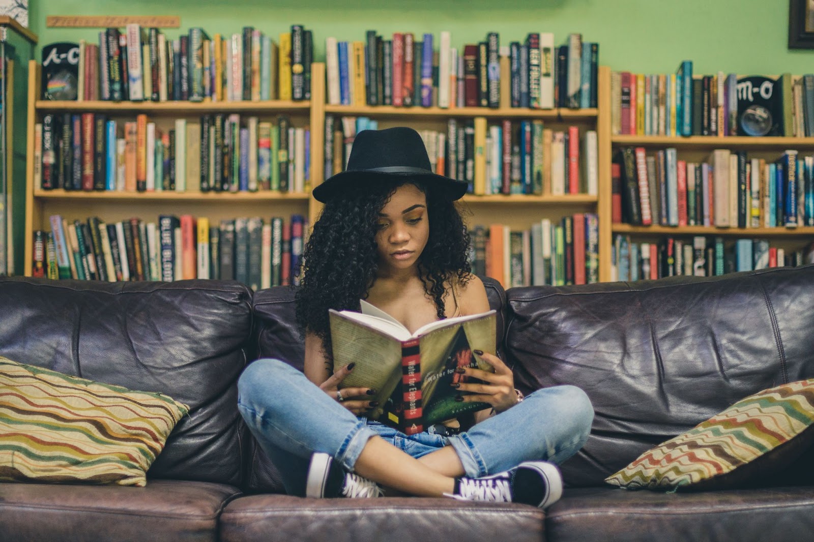 A girl reading a book on a sofa in a bookstore