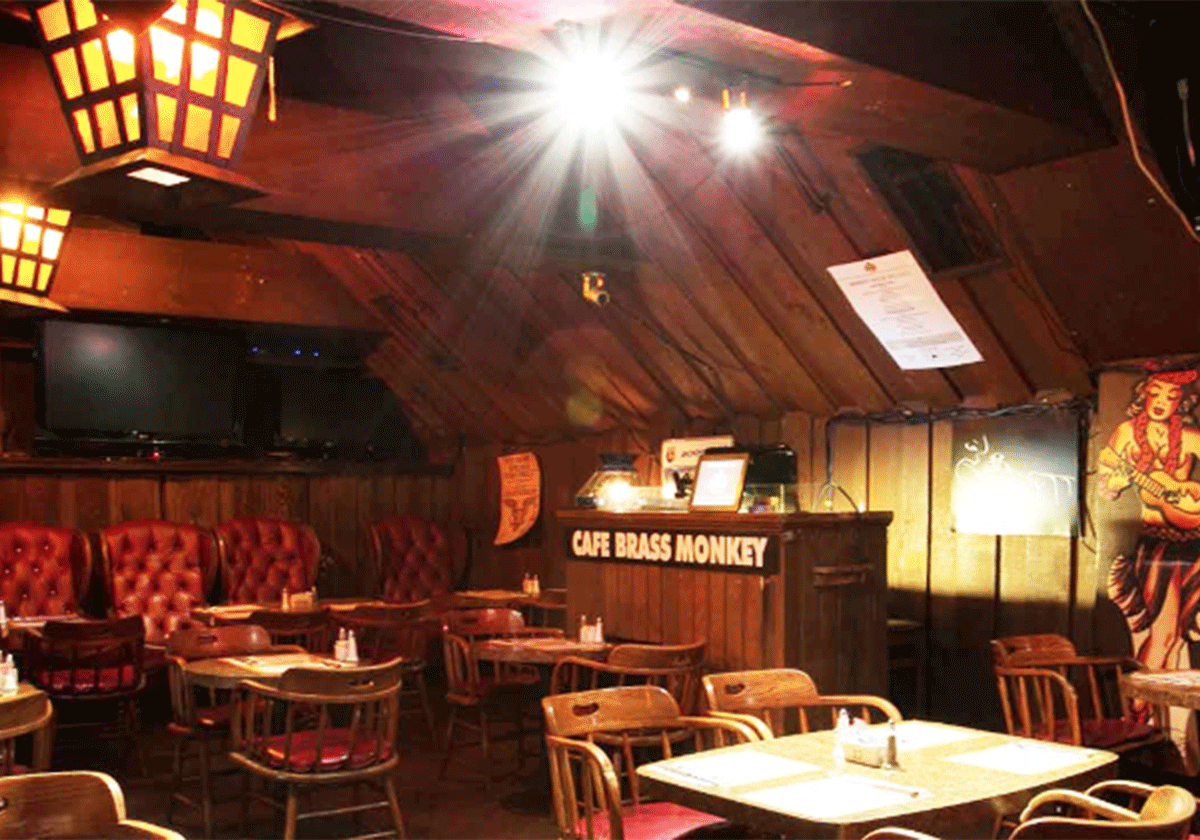 The interior of Cafe Brass Monkey with its classic wooden decor and maroon seating.