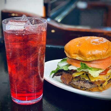 A burger and a drink on a table, Place: Champs Diner.