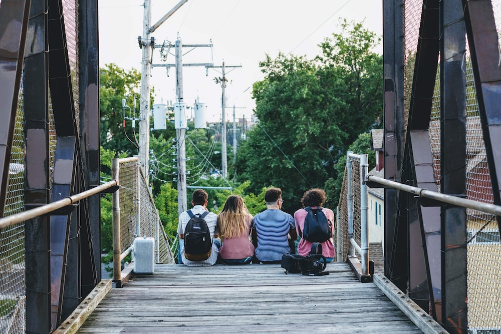 a group of people sitting on a bridge