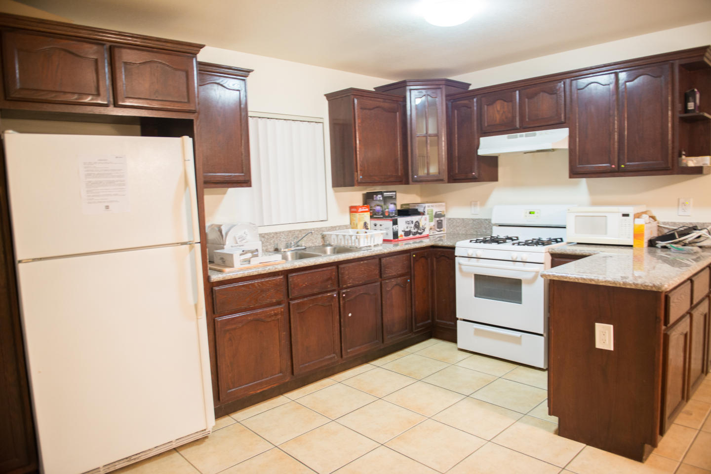 Large Kitchen, brown cabinets and white fridge